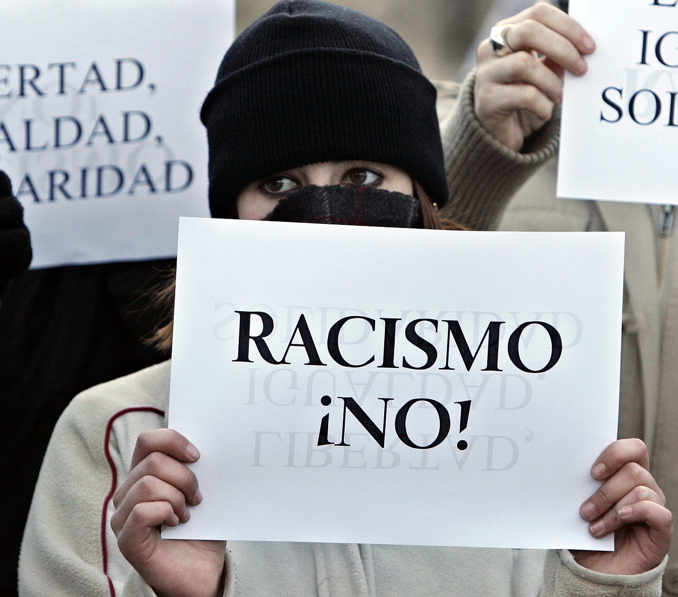 Una mujer posta una pancarta en la que se puede leer "Racismo ¡NO!" en una manifestación celebrada en Alcorcón en favor de los derechos humanos en España