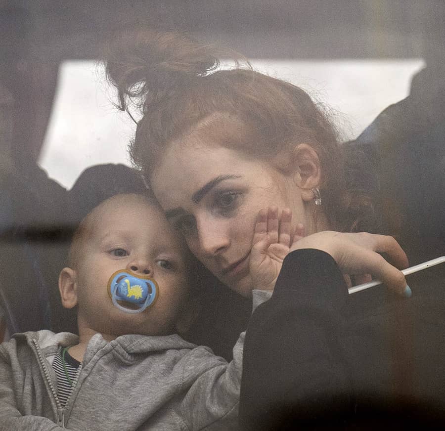 Una madre con su hijo huyen de los ataques rusos