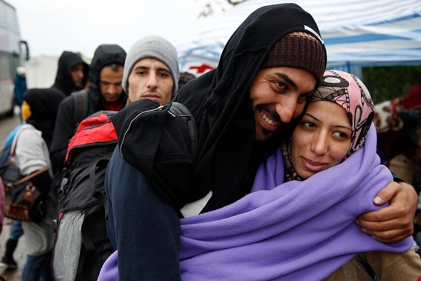 Una pareja sonríe mientras espera para cruzar la frontera serbiocroata en el pueblo de Berkasovo, cerca de Sid, Serbia.El derecho de asilo es un derecho humano