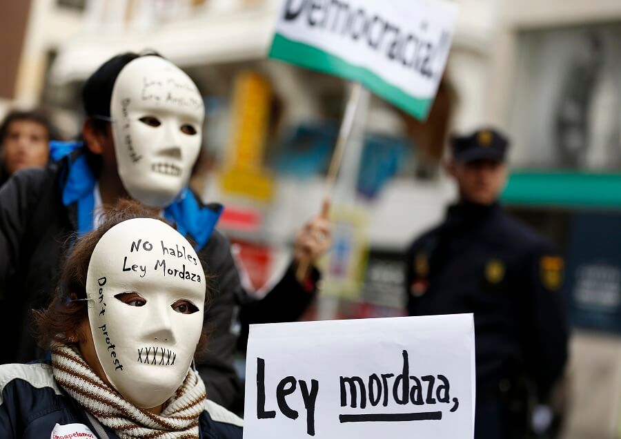 Varios manifestantes usan máscaras que dicen "No hables, ley mordaza" durante una protesta contra la nueva ley del gobierno español conocida como "Ley Mordaza".