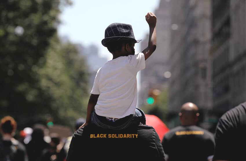 Un niño participa en un mitin mientras los manifestantes marchan por Central Park West durante los eventos para conmemorar el fin de la esclavitud en Texas, Nueva York, Estados Unidos, 19 de junio de 2020.El derecho al trabajo y al descanso son derechos humanos
