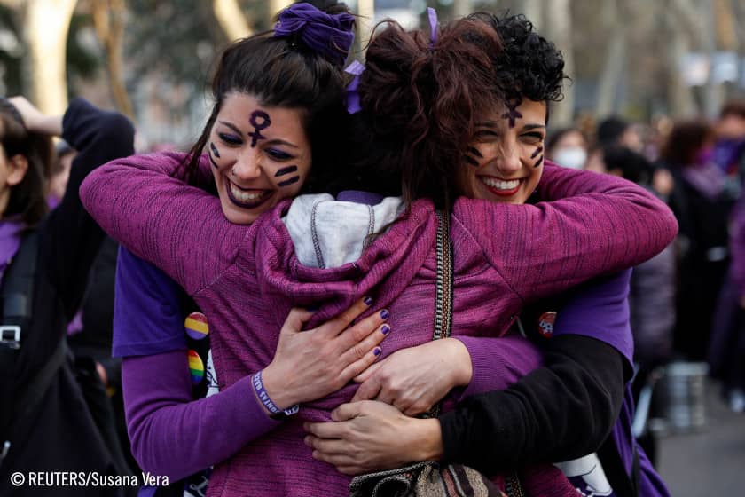 Tres mujeres se abrazan durante una marcha